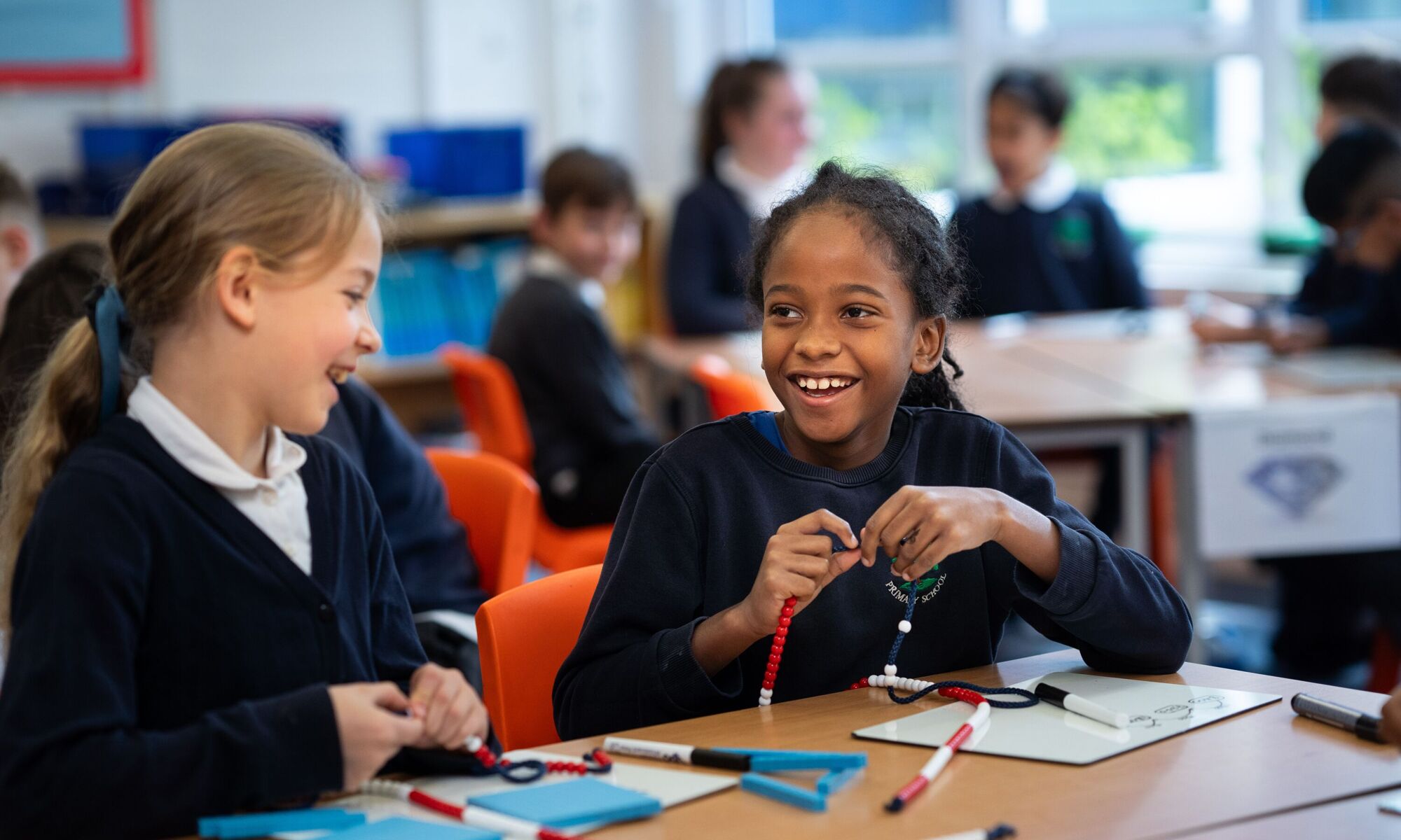 Girl connecting beads in classroom